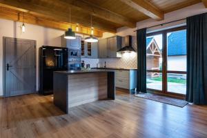 a kitchen with a large island in a room with wooden floors at TATRYSTAY Family Villa Rosa in Stará Lesná