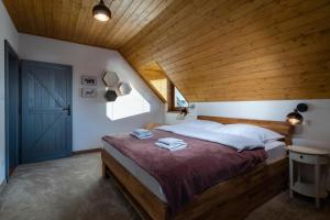 a bedroom with a large bed with a wooden ceiling at TATRYSTAY Family Villa Rosa in Stará Lesná