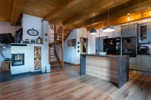 TATRYSTAY Family Villa Rosa في ستارا ليسنا: مطبخ مع أرضيات خشبية وقمة كونتر