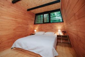 a bedroom with a white bed in a wooden wall at Eco Village In The Forest in Lagodekhi