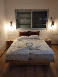 una camera da letto con un letto con due cuori sopra di מדבריות השחר a Dimona