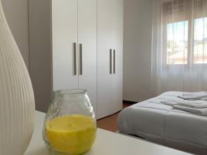 a glass jar of orange juice sitting on a table next to a bed at Elisa Appartamento con parcheggio in Levanto