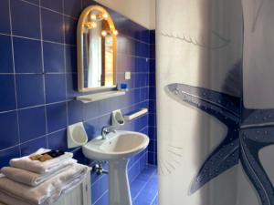 a blue bathroom with a sink and a mirror at Elisa Appartamento con parcheggio in Levanto