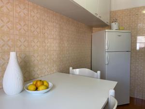 a kitchen with a white table with a bowl of fruit at Elisa Appartamento con parcheggio in Levanto