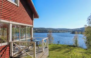 a house with a deck with a view of a lake at Beautiful Home In Bovik With Wifi 