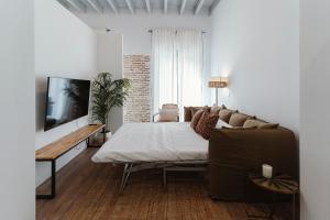un soggiorno con letto e divano di O&L Puñonrostro Bright Minimalist Central Home a Siviglia