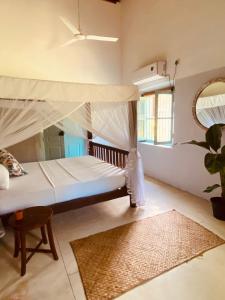 a bedroom with a canopy bed and a mirror at Cafe Ceylon in Koggala