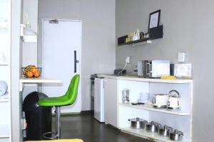 una cocina con una silla verde en una habitación en Air: Fox on Maboneng, en Johannesburgo