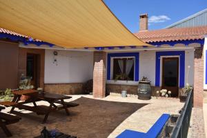 a patio of a house with a large yellow umbrella at Vivienda con piscina, gimnasio y cocina campera in Villanueva de los Infantes