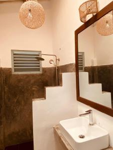 a bathroom with a sink and a mirror at Cafe Ceylon in Koggala