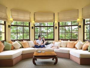 a man and woman sitting on a couch in a living room at Ana Mandara Villas Dalat Resort & Spa in Da Lat