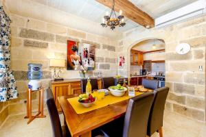 a kitchen with a wooden table with bowls of fruit on it at Ta Rena Holiday Home in Nadur