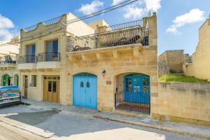 a building with blue doors on a street at Ta Rena Holiday Home in Nadur