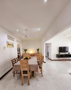 a dining room with a table and chairs and a television at Kaz Memel in Beau Vallon