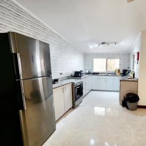 a kitchen with a stainless steel refrigerator and white cabinets at Kaz Memel in Beau Vallon