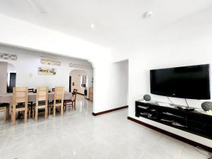 a living room with a television and a dining room at Kaz Memel in Beau Vallon