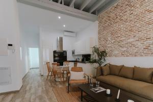un soggiorno con divano e muro di mattoni di O&L Puñonrostro Bright Minimalist Central Home a Siviglia