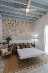 sypialnia z łóżkiem i ścianą z cegły w obiekcie One&Lux Puñonrostro Bright Minimalist Central Home w Sewilli