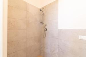 y baño con ducha y una gran pared de azulejos. en Attico Custonaci, en Custonaci
