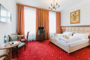 a hotel room with a bed and a table and chairs at Hotel Alt Görlitz in Görlitz