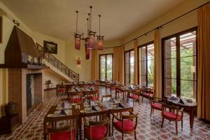 a dining room with tables and chairs and a fireplace at Ana Mandara Villas Dalat Resort & Spa in Da Lat