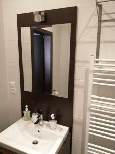 Un baño con un lavabo blanco y un espejo. en Panorama Apartmany, en Štrbské Pleso 81 fotos más