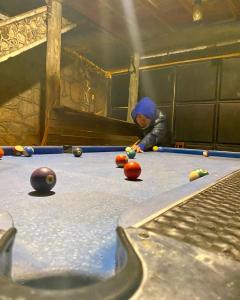 a man playing pool on a pool table at Hidden Valley Backpackers in Iringa