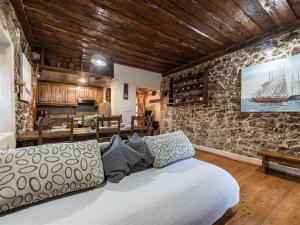 ein Wohnzimmer mit einem Bett und einer Steinmauer in der Unterkunft Stone Holiday house Zara with jacuzzi in Sukošan