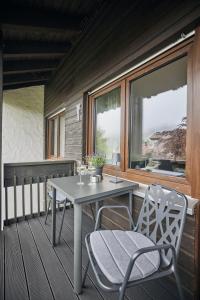 einen Tisch und Stühle auf einer Veranda mit einem Fenster in der Unterkunft Chalet Alpenruhe in Oberstaufen