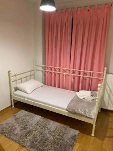 Cama en habitación con cortina rosa en Two Floor Luxurious Villa #skg, en Tesalónica