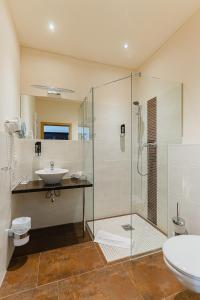 a bathroom with a glass shower and a sink at Hotel Alt Görlitz in Görlitz