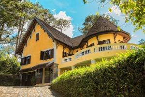 a yellow house with a gambrel roof at Ana Mandara Villas Dalat Resort & Spa in Da Lat