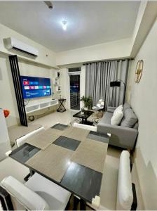 a living room with a dining table and a television at Twin lakes Merlot LL3-F in Tagaytay