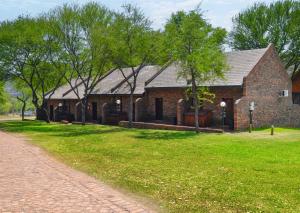 a brick building with trees in front of it at Olifants River Lodge by Dream Resorts in Middelburg