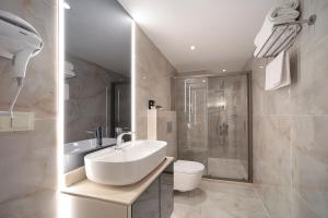 a white bathroom with a sink and a shower at Gatto Suites&Residence in Istanbul