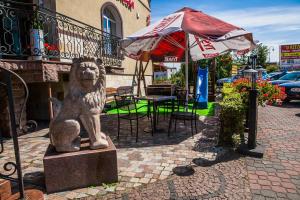 Une statue d'un lion assise à côté d'un parapluie dans l'établissement Kania Pokoje Gościnne, à Przodkowo