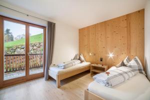 Zimmer mit 2 Betten und einem großen Fenster in der Unterkunft Residence Kalchgruberhof Fichte in Ulten
