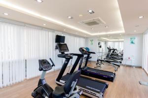 un gimnasio con varias cintas de correr y máquinas cardiovasculares en United Residence Ekamai Bangkok, en Bangkok
