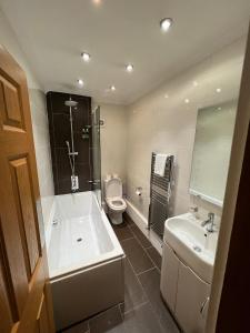 łazienka z wanną, toaletą i umywalką w obiekcie Melton Guest House w mieście York