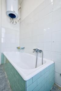 a bath tub in a white tiled bathroom at R&R Apartment in Marghera