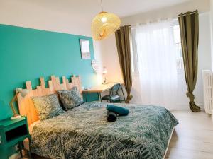 sypialnia z dużym łóżkiem i niebieską ścianą w obiekcie Cosy Summer 2CH - Parc Expo - 2 Balcons & stationnement gratuit w mieście Pau