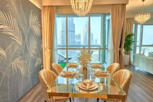 ein Esszimmer mit einem Glastisch und Stühlen in der Unterkunft Magnificent Luxury 3BR with Amazing Burj & Fountain view in Dubai