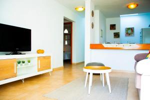 - un salon avec une télévision, une table et un tabouret dans l'établissement La Concha Beach apartament, à Arrecife