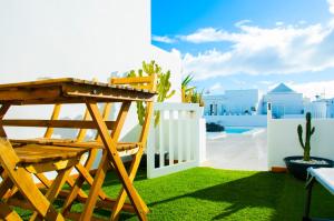 a yard with a wooden chair and a fence at La Concha Beach apartament in Arrecife
