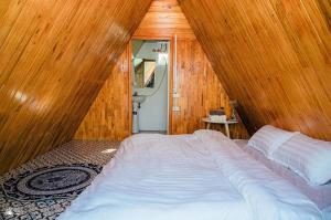 ハノイにあるNature’s House Ba Vi - Venue Travelの木製の壁に大きなベッドが備わるベッドルーム1室