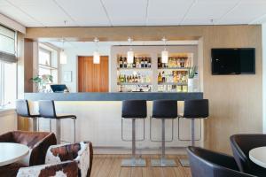 a bar in a restaurant with bar stools at Good Morning+ Göteborg City in Gothenburg