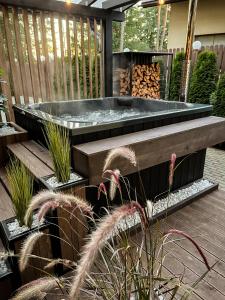 a hot tub in the middle of a deck with plants at Vanaga Ligzda in Baltezers