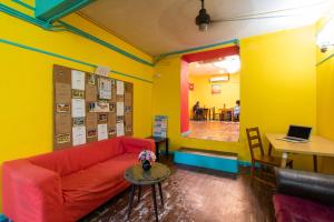 بيت ضيافة ترافل هوب في كوالالمبور: غرفة معيشة مع أريكة حمراء وطاولة