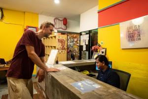 Dois homens num balcão num restaurante. em Travel Hub Guesthouse em Kuala Lumpur