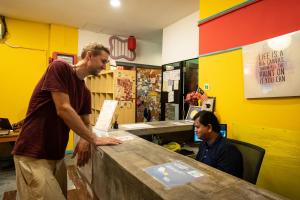 クアラルンプールにあるトラベル ハブ ゲストハウスの二人の男が店のカウンターに立っている
